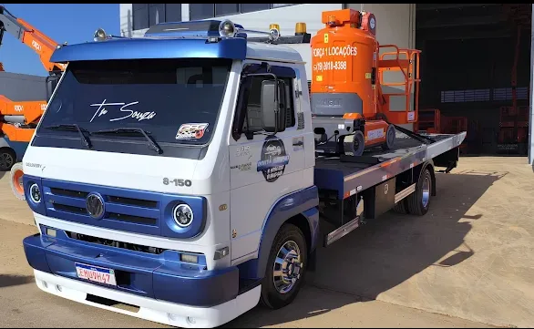 Caminhão plataforma transportando máquina de grande porte